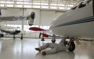 CT Aero student fixing parts under plane