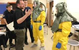 Criminal Justice and Protective Services Instructor directing students who are wearing protective gear
