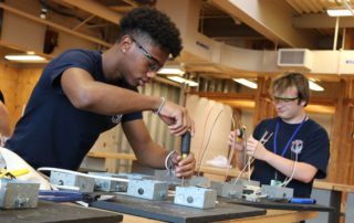 Two electrical students practice their wiring skills