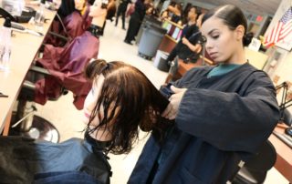 Hairdressing student practices skills on a mannequin