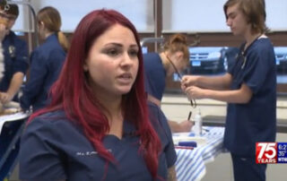 Image of Vinal Technical High School Veterinary Science Instructor Casandra Roman in her classroom with students and pets behind her.