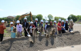 Local and state officials stand in front of a dirt pile holding shovels during the Bullard-Havens groundbreaking ceremony.