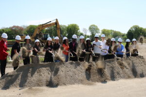 Bullard-Havens students hold shovels in front of a dirt pile at the 2023 groundbreaking ceremony for the new school