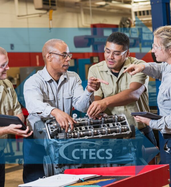 Older male instructs students in an auto shop.