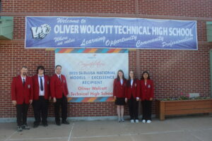 Staff and students stand in front of SkillsUSA banner outside of Wolcott Tech school building