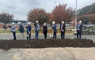 Special guests from CTECS, DAS, GreenBank and Verogy stand with shovels behind the ceremonial pile of dirt.